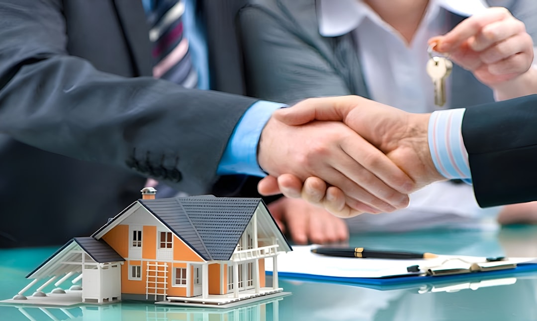 Two men shake hands over a miniature house model and a set of keys, symbolizing a property transaction.
